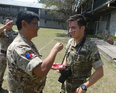 Senior Gurkha soldier putting on "tika" on Benjamin Atkinson's forehead after he completed his 10 week course.